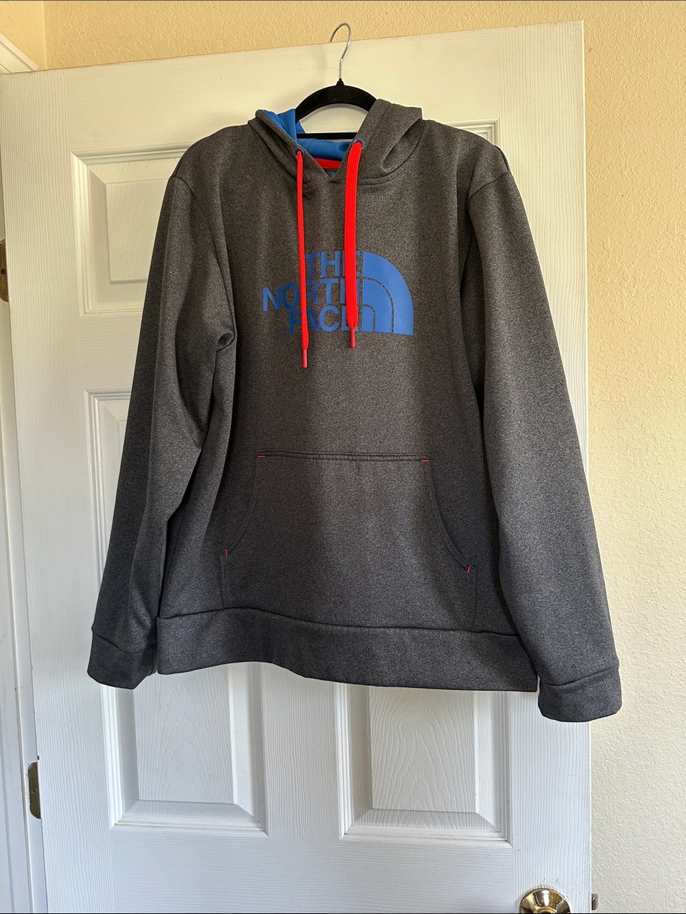The North Face Men's Charcoal Gray Hoodie with Blue Logo and Red Drawcords